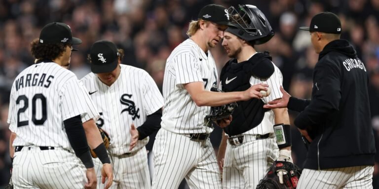Chicago White Sox players and staff gather on the field.