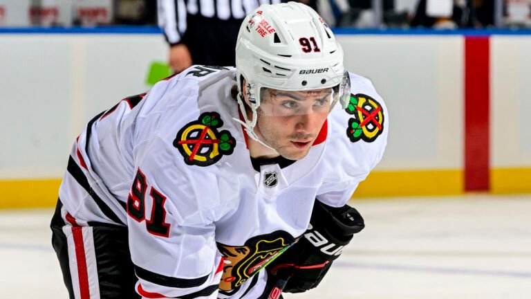 Frank Nazar wearing a white Chicago Blackhawks jersey and helmet.