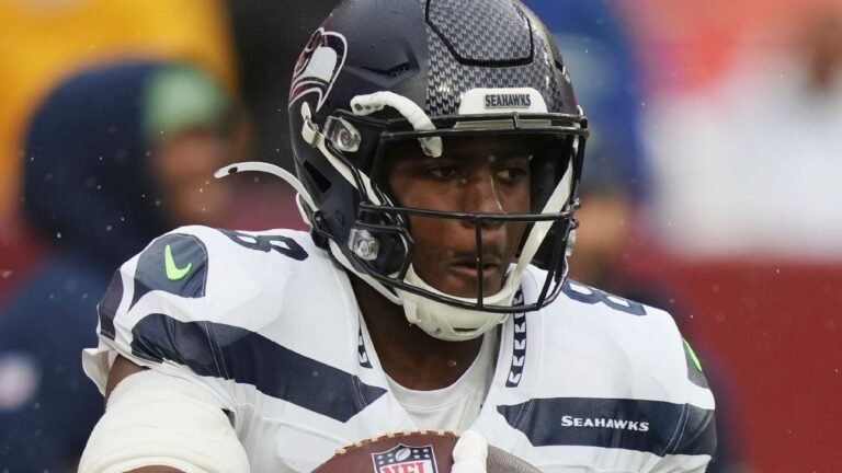 Jadarian Price holds a football while wearing Seattle&rsquo;s white uniform.