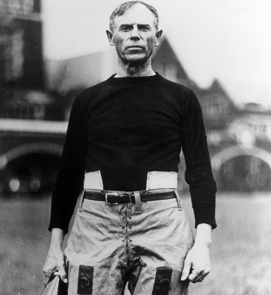 John Heisman standing on a football field
