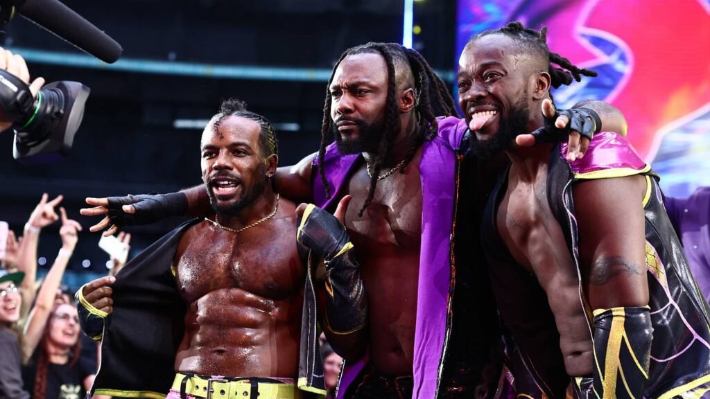 Swerve Strickland stands between two members of The New Level at ringside.