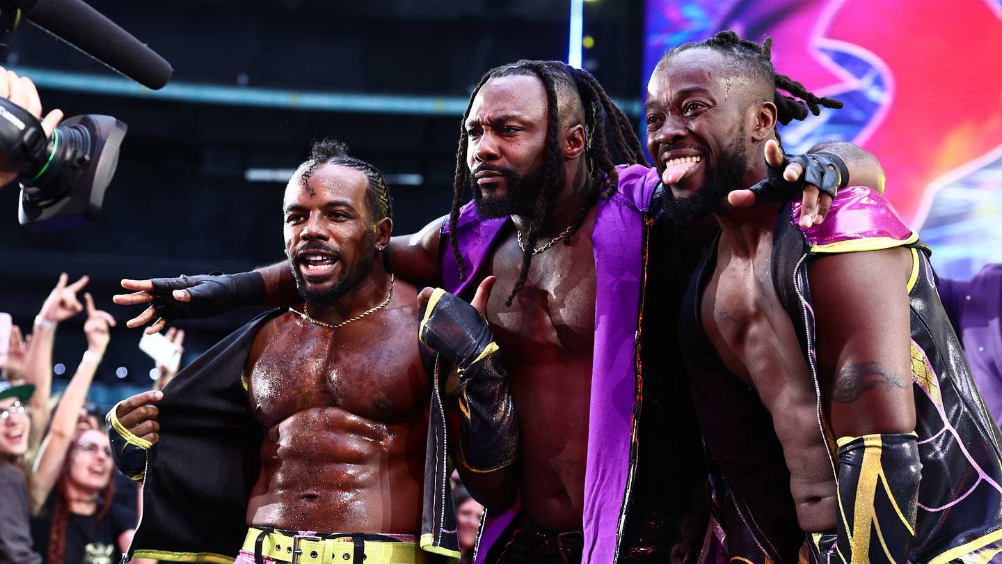 Swerve Strickland stands between two members of The New Level at ringside.