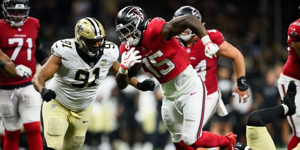 Falcons running back Brian Robinson Jr. scores with Saints defenders nearby.