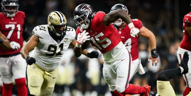 Falcons running back Brian Robinson Jr. scores with Saints defenders nearby.