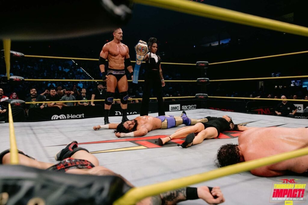 TNA wrestlers stand in the ring after a match.