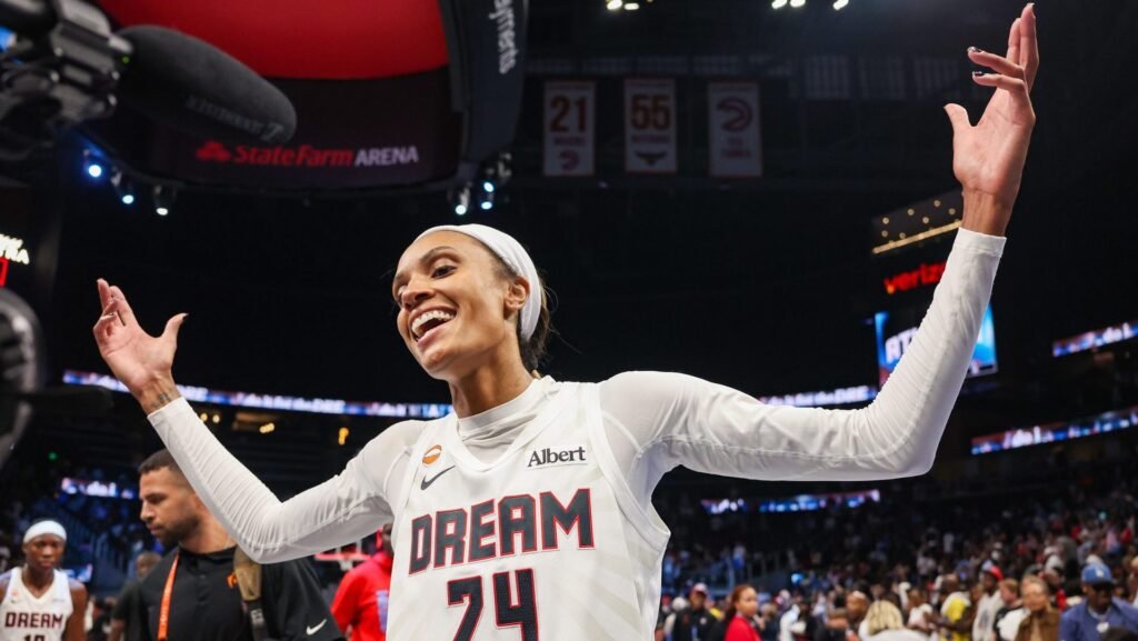 An Atlanta Dream player raises her arms at State Farm Arena.