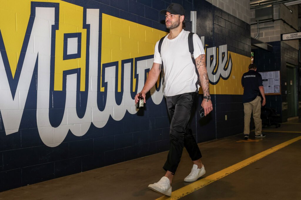 Lance McCullers Jr. walks through a corridor with Milwaukee Brewers lettering.