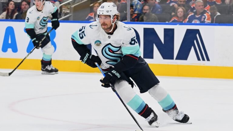 Ryan Lindgren skating in a white Seattle Kraken uniform