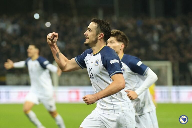 A Bosnia and Herzegovina player raises his fist beside teammates.