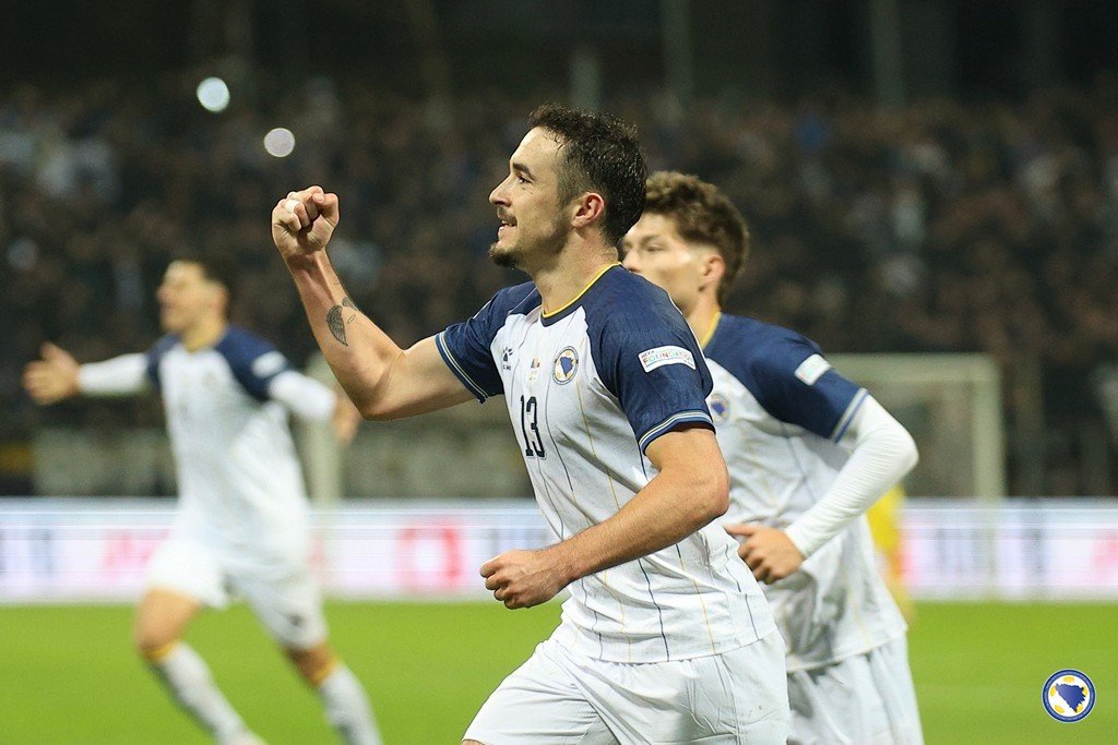 A Bosnia and Herzegovina player raises his fist beside teammates.