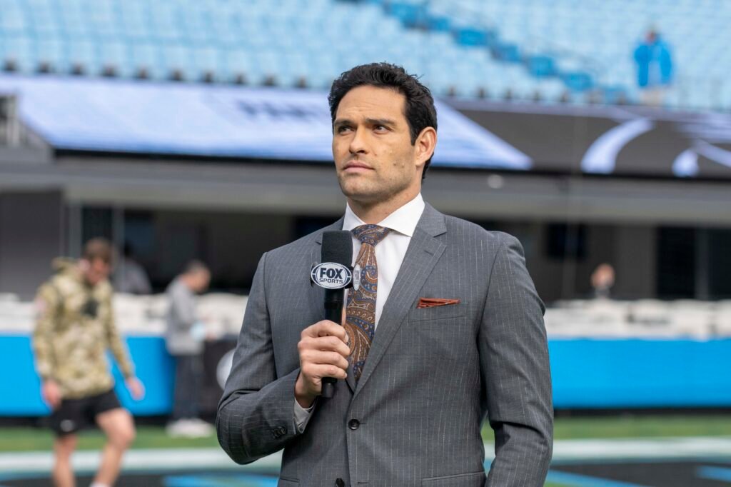 Mark Sanchez holds a Fox Sports microphone beside the field in Charlotte in 2021.