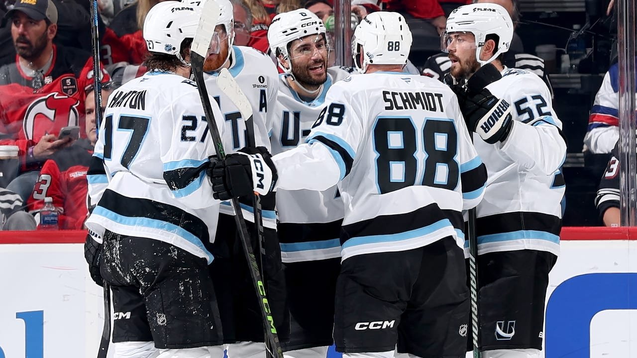Utah Mammoth players celebrating together in white uniforms