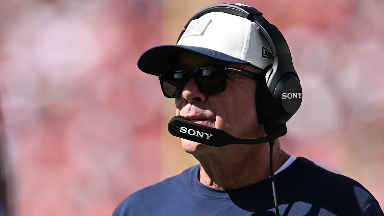 Sean Payton wearing a Broncos cap, sunglasses and a headset.