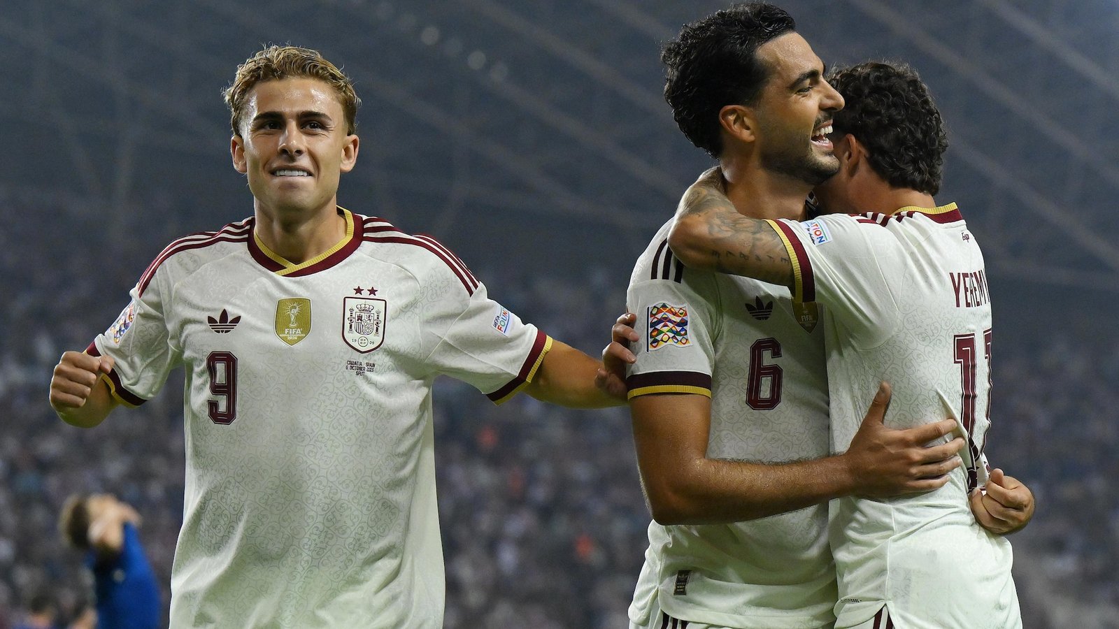 Mikel Merino smiles as Spain teammates embrace him after his winning goal against Croatia.