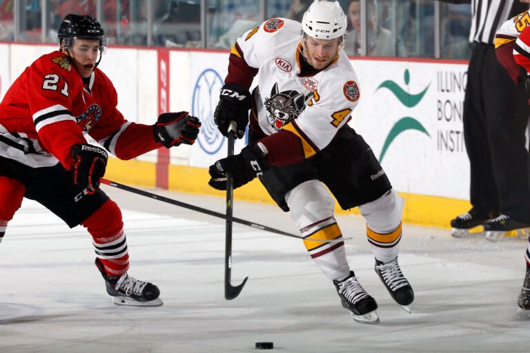 Teuvo Teravainen, left, in a red Rockford IceHogs jersey playing against Taylor Chorney in 2014