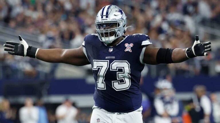 Dallas Cowboys guard Tyler Smith, wearing number 73, extends his arms on the field.