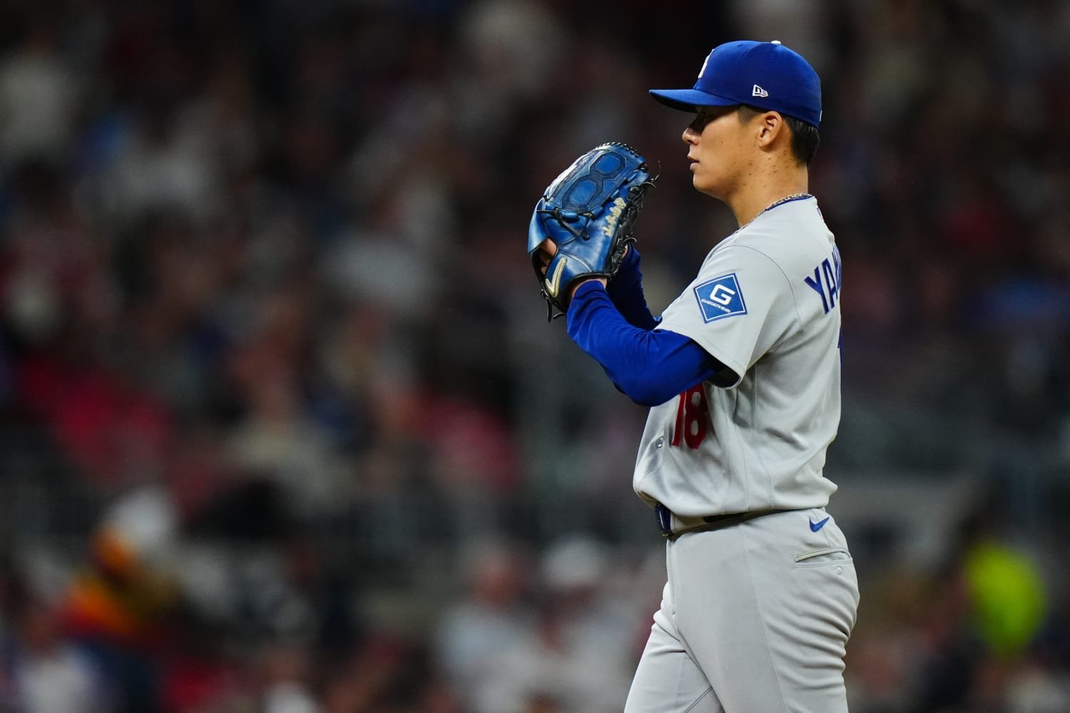 Yoshinobu Yamamoto stands on the mound with his blue glove raised during NLDS Game 3 at Truist Park.
