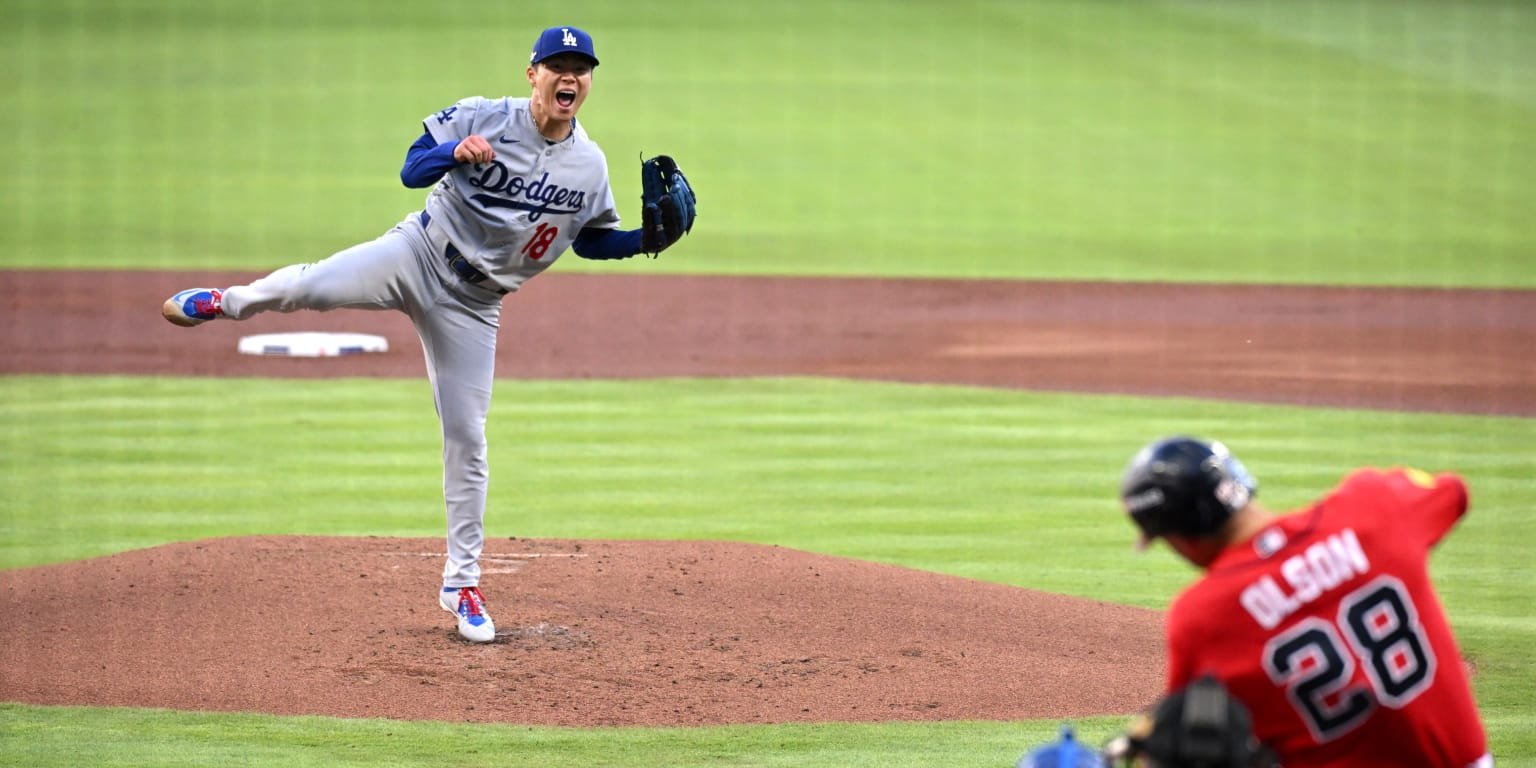 Yoshinobu Yamamoto finishes a pitch in a gray Dodgers uniform with Matt Olson batting for Atlanta.