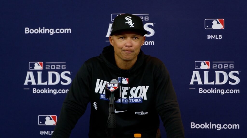 Will Venable in a black White Sox cap and hoodie speaks into a microphone in front of an ALDS backdrop.